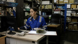 Fototapeta Paryż - Female worker counting goods in warehouse