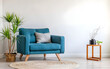 Cute blue loveseat sofa or snuggle chair and pot with branch. Interior design of modern living room with white wall with copy space. Created with generative AI 