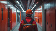 A worker in a red safety helmet walks with purpose through an industrial hall, evoking a sense of safety and professionalism