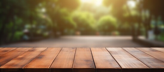 Poster - A wooden table made of hardwood with a wood stain finish, placed on a flooring with a blurred background of trees in a park