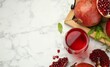 Tasty pomegranate juice in glass and fresh fruits on white marble table, flat lay. Space for text