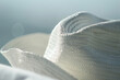 A white hat sitting on top of a bed. Perfect for fashion or interior design concepts
