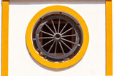 Fototapeta Boho - Round porthole window with a wheel in the wall of a house in Cadiz.