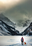 Fototapeta  - Backpacker Girl with her dog admires beautiful views of Lake Louise
