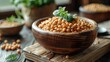Wooden bowl filled with soybeans topped with fresh basil leaves on a rustic table