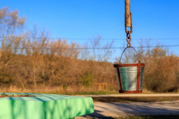 Wall Mural - A bucket is hanging from a chain