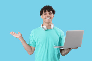 Wall Mural - Male programmer with laptop showing something on blue background