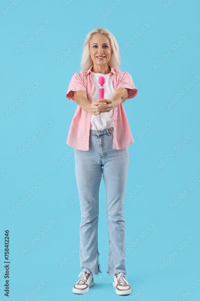 Mature woman with vibrator on blue background