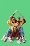 Fototapeta Panele - Little children with their parents and cardboard paper on green background