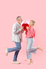 Canvas Print - Mature couple with gift and balloons on pink background. Valentine's Day celebration