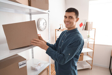 Wall Mural - Male online store seller with parcel box on shelf in warehouse