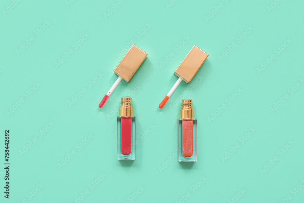 Different lip glosses on turquoise background