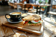 a nice sandwich and a cup of coffee on a table on a cafe background. Breakfast in a cafe. business style 