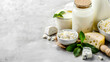 Creative banner for healthy farm dairy products store: Assortment of dairy products on light table - milk, cottage cheese, natural farm. Copy space with mint leaf accent.





