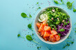 A vibrant and nutritious lunch bowl showcasing salted salmon salad, set against a pale blue backdrop.





