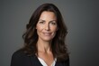 © Igor - Portrait of a beautiful business woman smiling at the camera over grey background