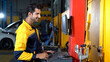 happy latin auto mechanic man using computer checking Center and balance the wheels in garage cars service. hispanic technician touching monitor balancing tires repairing vehicle at garage .