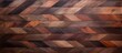 A closeup image of a brown hardwood wall with a geometric pattern of triangles and rectangles. The wood flooring has tints and shades of magenta, resembling a brick wall