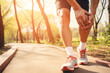 Runner Experiencing Knee Pain While Jogging on a Sunny Park Path, Health and Exercise Concept