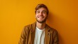 © hakule - Young Man Smiling Against a Yellow Wall
