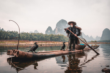 Wall Mural - Cormorant fisherman and his birds on the Li River in Yangshuo, Guangxi, China.