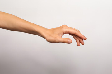 Sticker - Woman's hand holding something on a gray background. Close up.