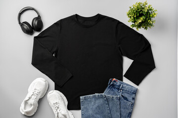 Wall Mural - T-shirt, jeans and white sneakers on gray background top view