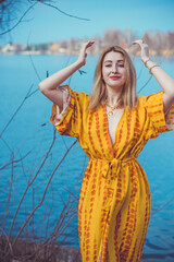 Wall Mural - Woman in yellow cotton dress and golden accessorize like a sun. Natural women's beauty without retouch, nature background