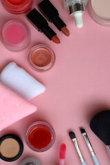 Various colorful beauty products on bright pink background. Top view.