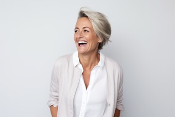 Wall Mural - Portrait of happy mature businesswoman laughing and looking away against grey background
