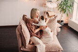 Fototapeta Zwierzęta - Middle age Woman with her Dog resting on sofa at Home