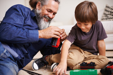 Sticker - Grandfather, laugh and toy train with boy child, playing and bonding in family lounge. Grandpa, young kid and childhood development with games and fun, quality time and love with elderly retired man