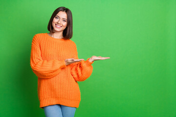 Wall Mural - portrait of nice cheerful girl arms palms hold demonstrate empty space proposition isolated on green