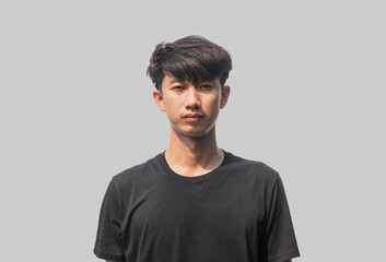 A young Asian man in his 20s wearing black t-shirt is depressed and worried in distress standing on a gray background. Crying in anger and fear. Sad expression concept