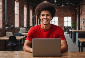 Canvas Print - A happy young man with curly hair working on his laptop, the epitome of relaxed professionalism.