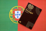 Fototapeta  - Red Portugal passport of European Union on national flag background close up. Tourism and citizenship concept