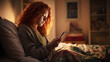 Still cozy in bed, beautiful irish redhead woman awakes early morning, finds herself relaxed, seriously concentrating on smartphone alarm clock time in her comfortable bedroom.