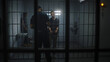 © Framestock - Warden brings young prisoner in jail cell and takes off his handcuffs. Multi ethnic teenagers serve imprisonment term in correctional facility or detention center. Guilty inmates in prison cells.