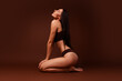 © deagreez - Full body photo no retouch of pretty young girl sit floor body positive dressed stylish underwear isolated on brown color background