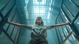 Fototapeta  - Kobieta o rozpostartych ramionach stoi w wąskim korytarzu więziennym, zamykając drzwi z kratami. Mroczna scena braku wolności.