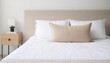 Beige cushion on white bed