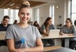 © natakot - Young woman in a classroom with peers. Looking at camera with a focused, academic setting behind her.