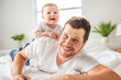 © Louis-Paul Photo - bearded father holding baby boy on bed, fatherhood and love