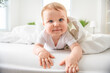 © Louis-Paul Photo - Baby boy in white sunny bedroom. one years child relaxing in bed.
