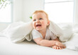 © Louis-Photo - Baby boy in white sunny bedroom. one years child relaxing in bed.