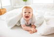 © Louis-Photo - Baby boy in white sunny bedroom. one years child relaxing in bed.