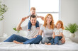 © Louis-Photo - happy family mother, father and children having fun in bed in bedroom at home
