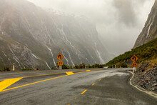 Water from torrential rain and snow-melt rushes down steep rockfaces toward a hairpin turn on State Highway 94, in Fiordland, New Zealand, the road to Milford Sound