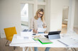 © epiximages - beautiful architect, woman, business woman wearing black glasses standing at working table in office, loft