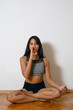 young latin woman practicing yoga at home doing breathing exercises and mudras